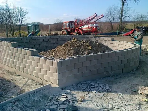 Támfal építése beton zsalukőből, gépi földmunkával és tereprendezéssel az Ujj Trans Kft. kivitelezésében